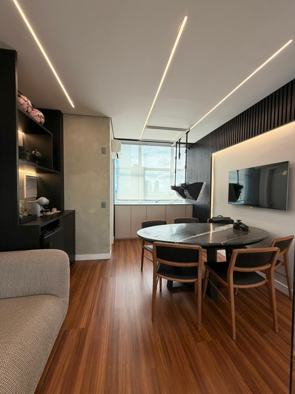 Sala de espera e convivência da Villodonto com mesa de mármore e iluminação linear